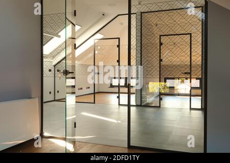 Interior of modern offices, entry walls and doors made of glass, loft part of a building. Stock Photo
