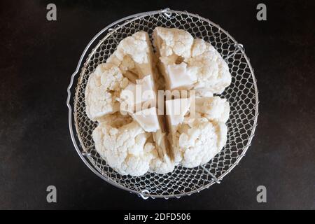 Raw fresh cauliflower ready to cook in a cooking basket Stock Photo