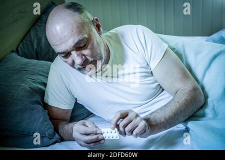 Man taking sleeping pills. Stock Photo
