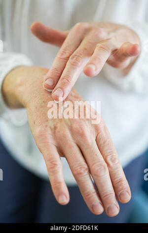 Woman applying cream on her hands. Stock Photo