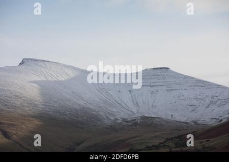 Libanus, Brecon Beacons, South Wales, UK.  4 December 2020.  UK weather:  Snow covers the mountains this afternoon after last nights flurries.  Credit: Andrew Bartlett/Alamy Live News Stock Photo