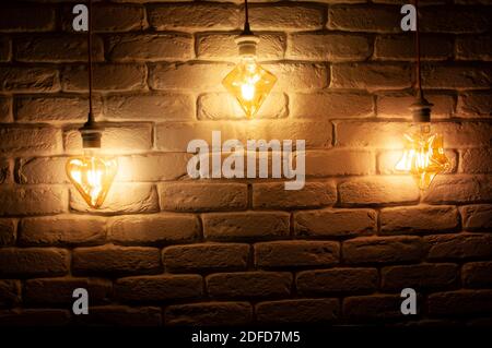 Lights on the wire hanging on the wall. The lights in a dark room. Stock Photo