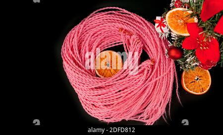 Synthetic pink kanekalon braids - Christmas photo with decoration on black. New Year photo for a store or hairdressing salons, barbershops Stock Photo