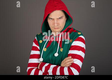 Man wearing Grinch costume making grumpy face on grey background Stock Photo
