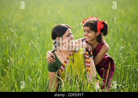 Happy mother and daughter at agricultural field Stock Photo
