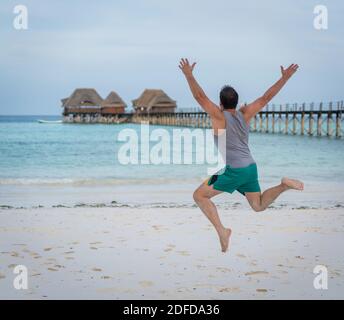 Jumping man on tropical beach Stock Photo