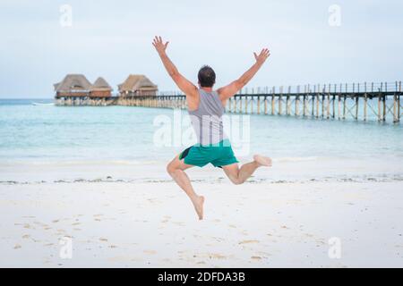 Jumping man on tropical beach Stock Photo