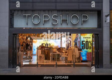 Oxford Street, London, UK. 4 December 2020. Busier day in Oxford Street despite cold and drizzle as shoppers look for bargains pre-Christmas. Arcadia Group’s TOPSHOP flagship store entrance in Oxford Circus advertising  up to 50% off, the company is in Administration. Credit: Malcolm Park/Alamy Live News Stock Photo