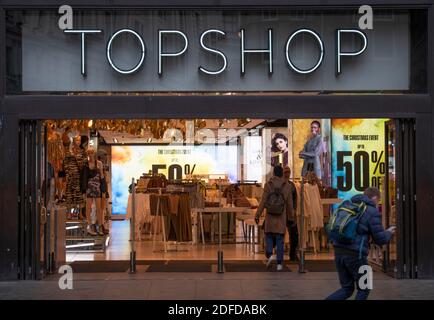 Oxford Street, London, UK. 4 December 2020. Busier day in Oxford Street despite cold and drizzle as shoppers look for bargains pre-Christmas. Arcadia Group’s TOPSHOP flagship store entrance in Oxford Circus advertising  up to 50% off, the company is in Administration. Credit: Malcolm Park/Alamy Live News Stock Photo