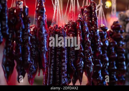 Traditional georgian sweet dessert churchkhella hanging at Christmas market in neon lights Stock Photo