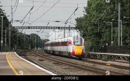 Azuma high speed train in LNER livery speeding through a railway station in the UK. Stock Photo