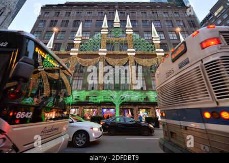 New York, USA. 03rd Dec, 2020. Between passing commuter buses, the Saks Fifth Avenue department store holiday lights are displayed to accompanying music every night after sunset in New York, NY, on December 3, 2020. (Photo by Anthony Behar/Sipa USA) Credit: Sipa USA/Alamy Live News Stock Photo