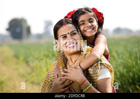 Happy mother and daughter at agricultural field Stock Photo