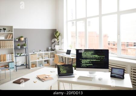 Image of workplace with computers and digital tablet with software on the screens in modern office Stock Photo