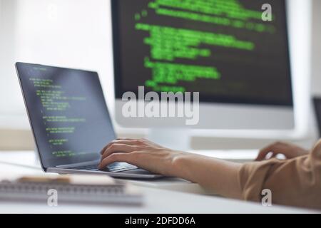 Close-up of developer developing new program while typing on laptop at the table at office Stock Photo