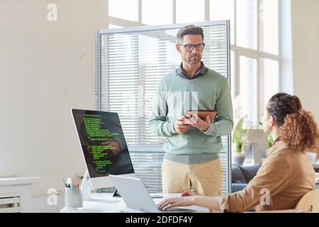 Two business colleagues using digital tablet and computers in their work at office Stock Photo
