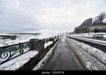 Horseshoe Falls and the path along the edge of Niagara gorge during winter after snowfall.  The path and road have been cleared of snow and ice. Stock Photo