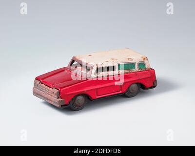 A rustic red and white tin toys van in the grey rustic tin toys van  at grey background Stock Photo