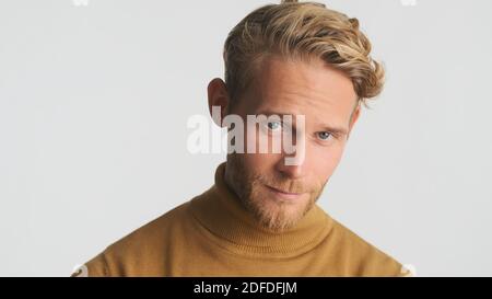 Handsome bearded man in casual wear looking intently in camera over white background Stock Photo