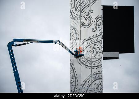 Glasgow, Scotland, UK. 4th Dec, 2020. Pictured: Workmen in PPE high viz orange seen on a cherry picker doing the finishing touches to the M8 Tower - a 131ft high stainless steel structure adorned with the teardrop paisley pattern shape, showcasing a giant electronic advertising display board above the White Cart Viaduct, which will showcase adverts to traffic in north directions. The structure cost more than a million pounds, being funded by Wildstone, the UK's largest outdoor advertising firm. Credit: Colin Fisher/Alamy Live News Stock Photo