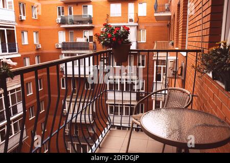 Cozy balcony with flowers. View of the courtyard of a brick house. Stock Photo
