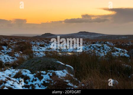 Princetown, Dartmoor, Devon, UK.  4th December 2020.  UK Weather.  Sunset viewed from the snow covered moorland at Princetown on Dartmoor in Devon looking towards Leather Tor and Sharpitor at the end of a cold wintery day.  Picture Credit: Graham Hunt/Alamy Live News Stock Photo