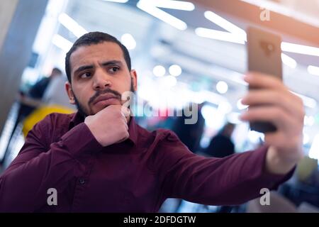 Smiling young african  man using smartphone in a modern cafe Stock Photo