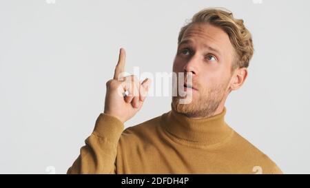 Young attractive bearded man thinking and showing new idea gesture on camera over white background Stock Photo