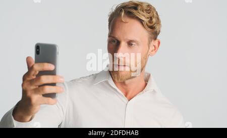 Handsome bearded businessman confidently talking on video chat isolated on white background Stock Photo