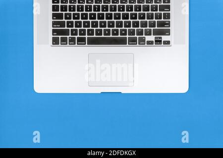 Close Up Overhead of Laptop Keyboard on Blue Background Stock Photo