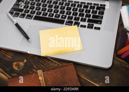 Close Up of Sticky Note Paper and Laptop on Rustic Wood Background Stock Photo
