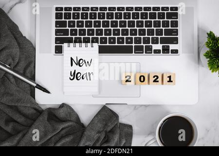 New Year, New Start. Paper and Laptop on Work Desk Over White Desk. 2021. Stock Photo