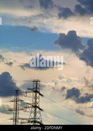 High voltage power lines under blue cloudy sky with plenty of room for copy and text Stock Photo