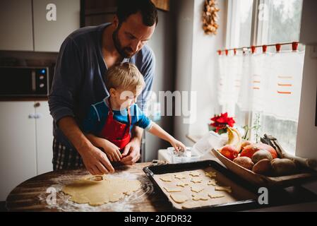 Father and son in kitchen at home baking Christmas cookies in Pajamas Stock Photo