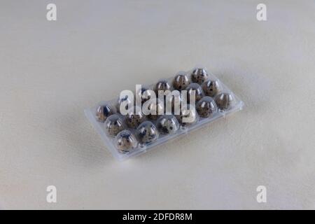 Quail eggs in a plastic packaging, plastic envelop to protect the eggs, on beige color background. Farmers market eggs Stock Photo