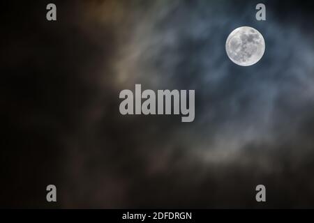 Full moon shining on dark night sky Stock Photo
