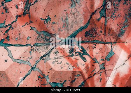 Cracked concrete wall covered with red paint Stock Photo