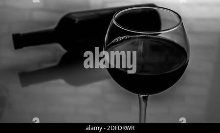 https://l450v.alamy.com/450v/2dfdrwr/a-glass-of-red-wine-with-a-bottle-of-wine-black-and-white-picture-of-wine-in-a-glass-2dfdrwr.jpg