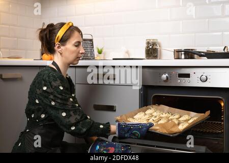 Women preparing homemade food pie, pizza in a cozzy kitchen. Hobbies and family life concept. Stock Photo