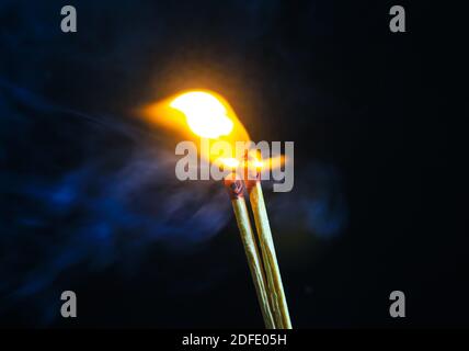 Couple of matches burning together with heat flame isolated on a black background. Stock Photo