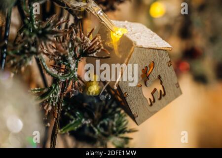 Decorative Christmas garland in the form of wooden house close-up. Isolated on a brick wall background. Christmas or new Year background. Stock Photo