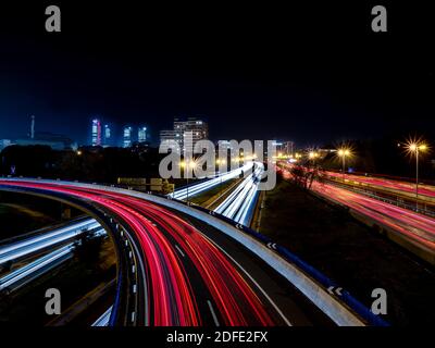 Light trails produced at dusk by the headlights and tail lights of cars from a bridge Stock Photo