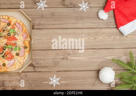 Pizza delivery for Christmas holidays. Pizza in a box on a table with a copy space Stock Photo