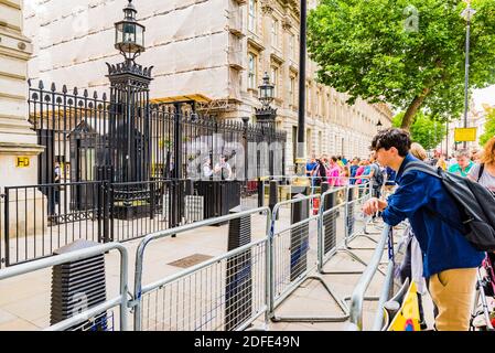 People behind the fence observe the entrance to the residence of the Prime Minister in Downing street. London, England, United Kingdom, Europe Stock Photo