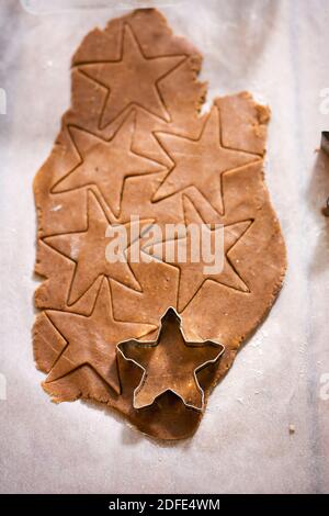 Raw rolled gingerbread dough, cutting festive shaped cookies Stock Photo