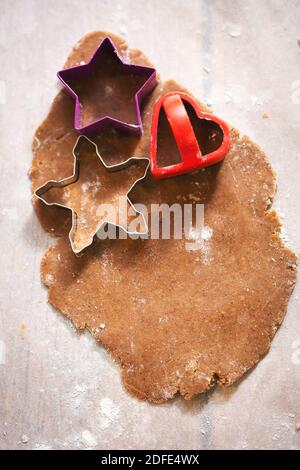 Raw rolled gingerbread dough, cutting festive shaped cookies Stock Photo