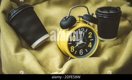 Coffee in a plastic cup with retro clock and alarm clock,close-up. Stock Photo
