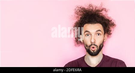 Human emotions concept. Surprised young crazy man feeling stress from shopping. Closr up shot of stupefied handsome male opens mouth wide, has shocked Stock Photo