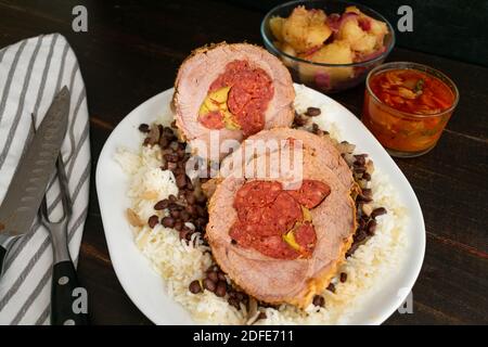Boliche (Cuban Pot Roast): Roast beef stuffed with chorizo sausage and olives served on a platter of black beans and rice Stock Photo