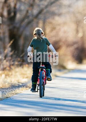 Happy young boy riding his bike on a paved trail; Salida; Colorado; USA Stock Photo